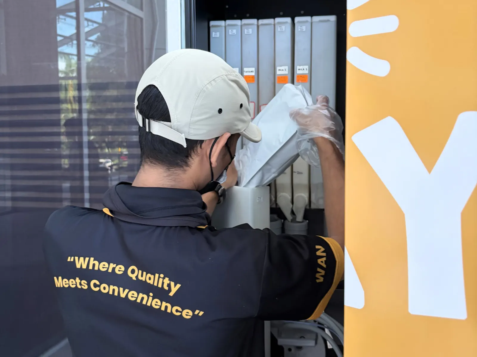 A technician in an Otter polo servicing the back of a machine