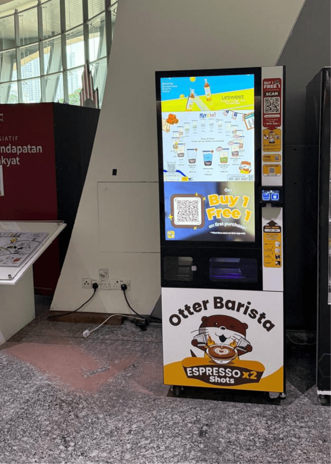 Sleek Otter robot dispensing espresso drinks into ceramic cups at a modern Klang Valley office pantry station surrounded by colleagues during morning break.