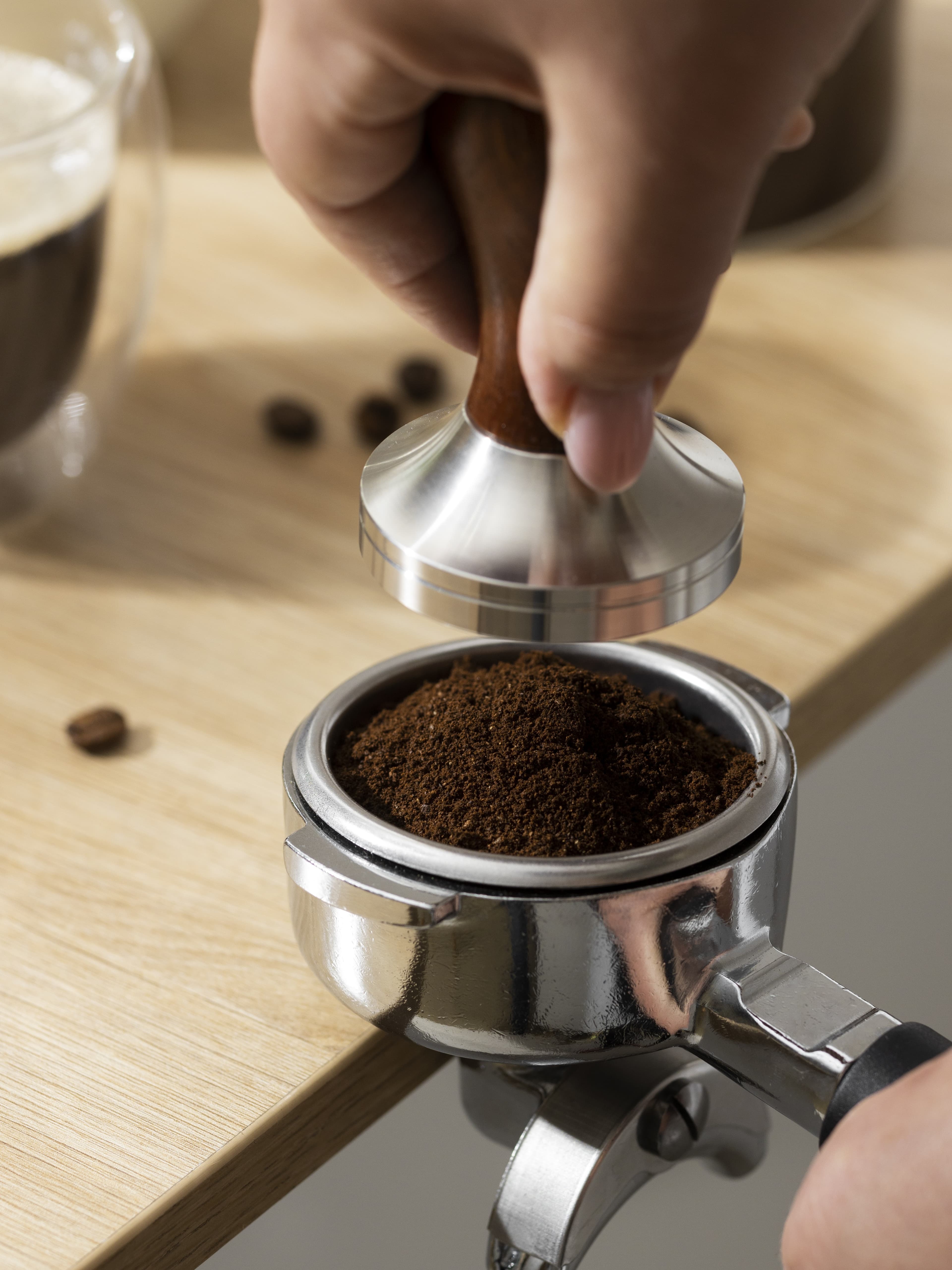 Otter robotic barista dispensing fresh espresso into a cup while office workers queue at a modern pantry station during morning break.