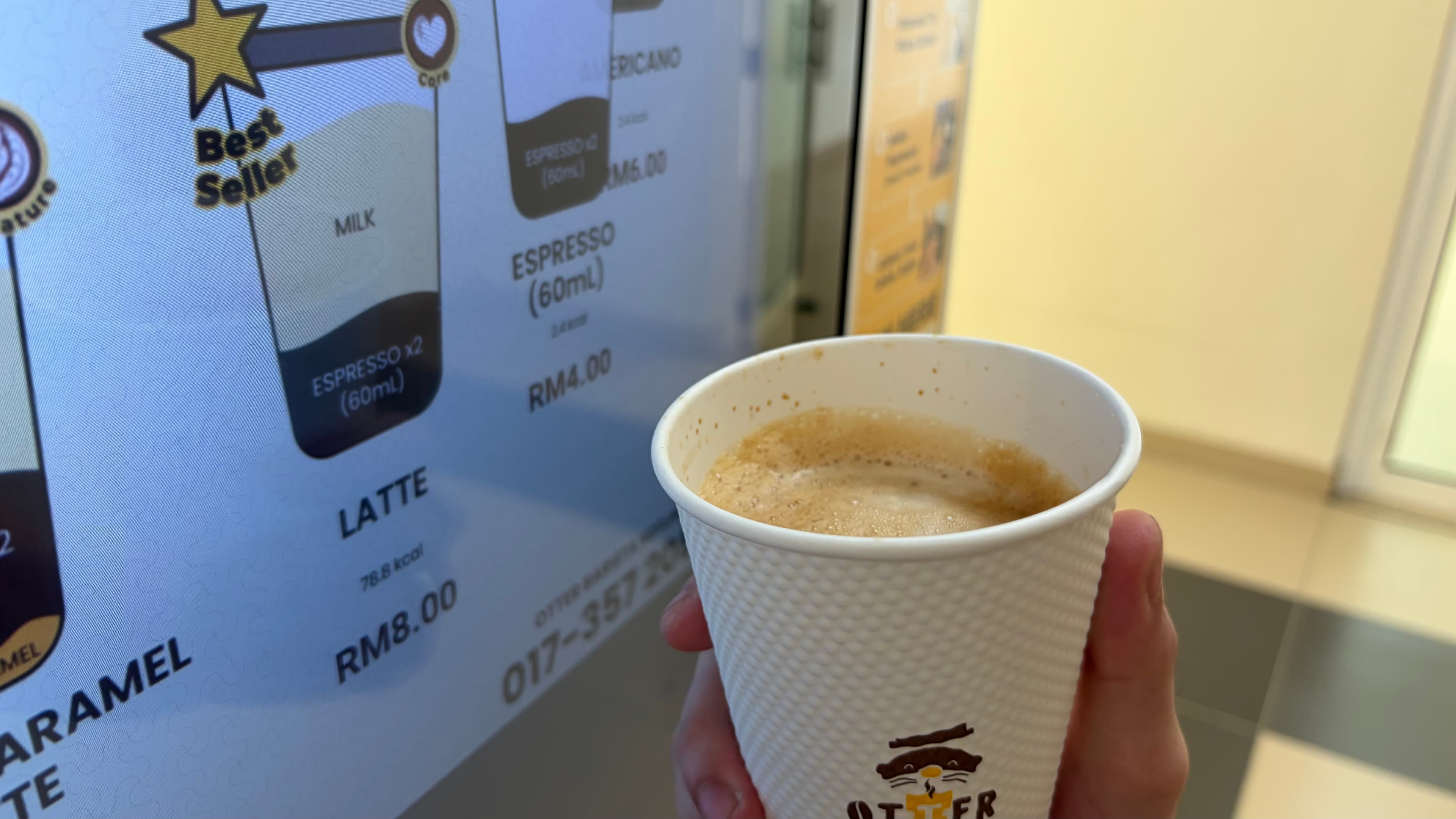Sleek Otter robotic barista dispensing fresh espresso into a ceramic cup in a modern office pantry during morning break.